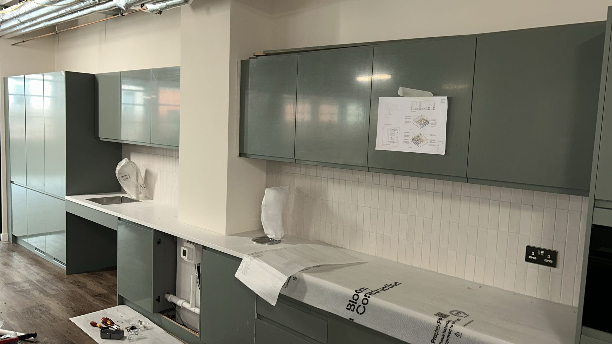 L-shaped tea-point with quartz worktop and vertical stack-tile splashback
